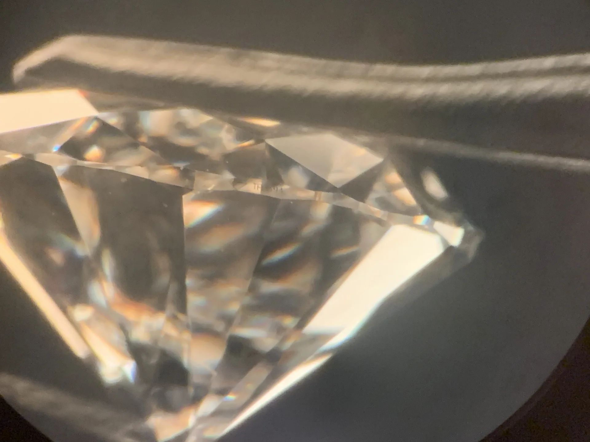 Diamant im Brillantschliff, Seitenansicht im Dunkelfeld: Rundiste mit Laserinschrift